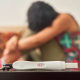 positive pregnancy test and sad woman